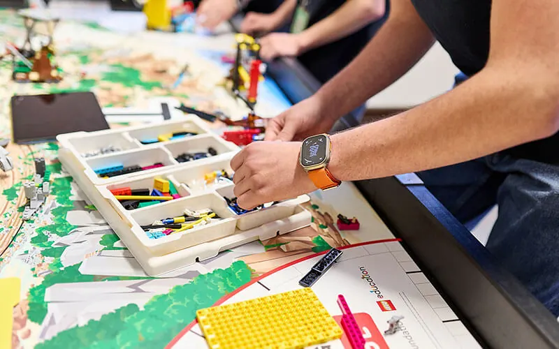 Hände setzen LEGO-Elemente am Wettbewerbsmodell ein